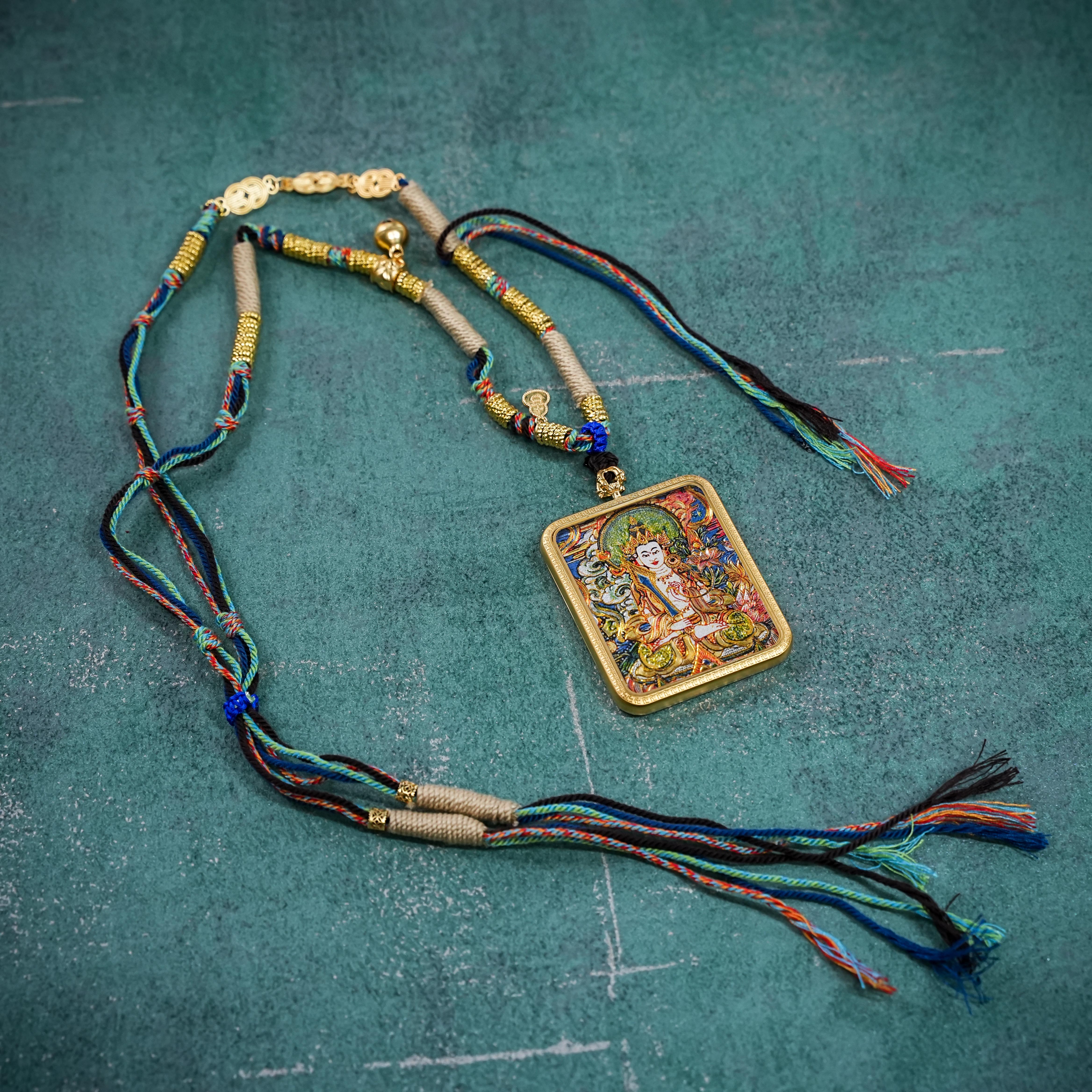 Ākāśagarbha thangka gau pendant with hand-woven cord on teal stone