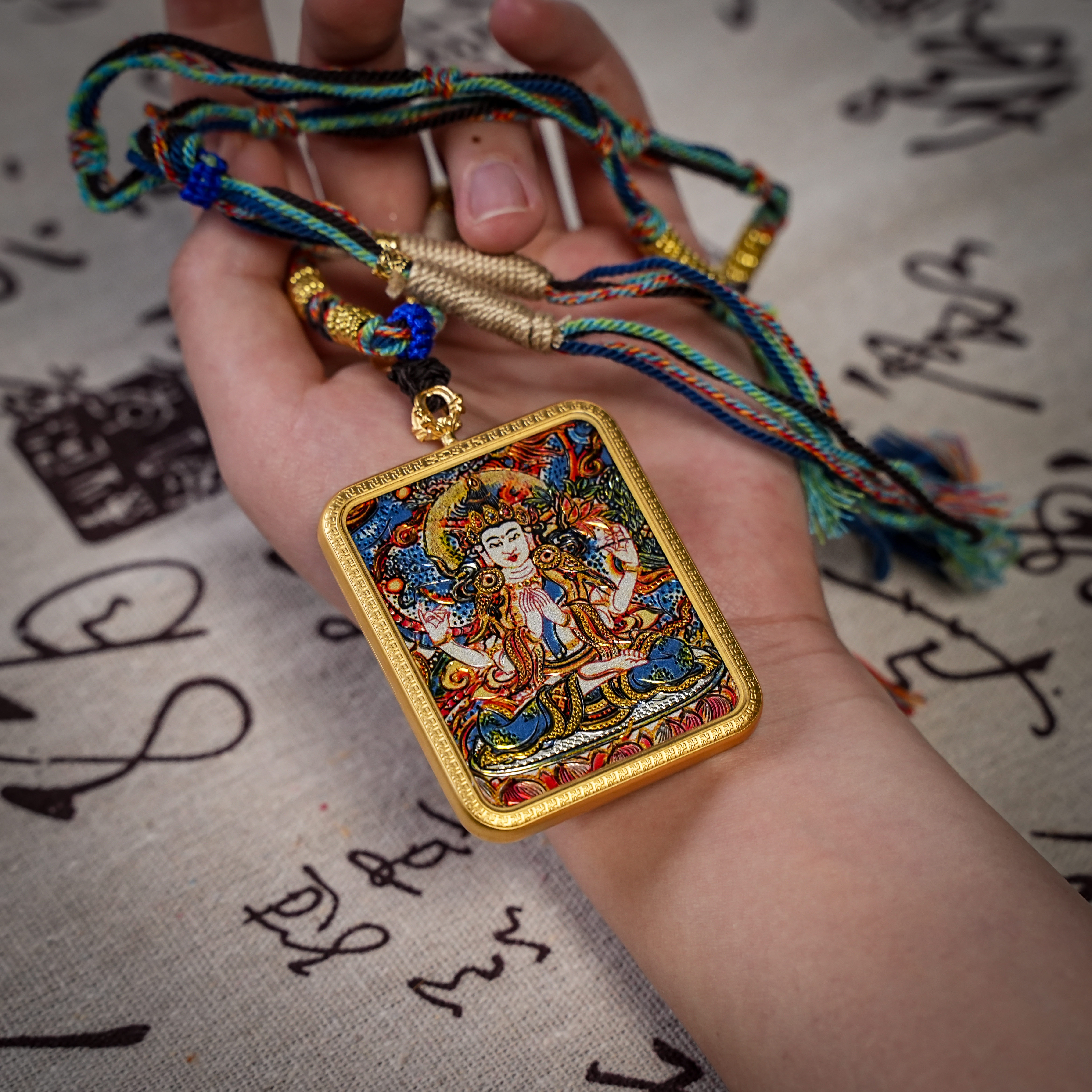 Thousand-armed Avalokiteśvara thangka gau pendant held in hand